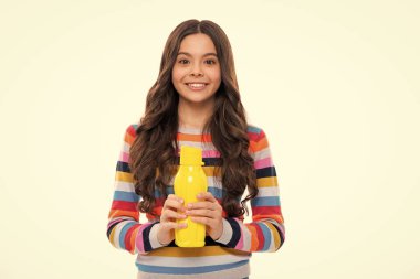 Su şişesi ile izole edilmiş stüdyo geçmişi olan bir çocuk. Su şişesi ve sağlıklı yaşam. Sağlık ve su dengesi. Mutlu kız yüzü, pozitif ve gülümseyen duygular