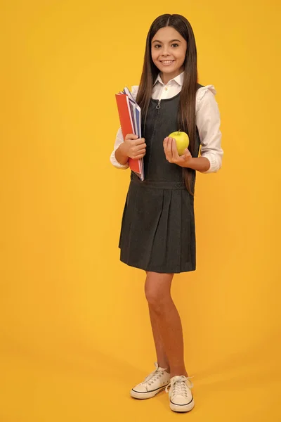 Niña de la escuela en uniforme escolar con mochila escolar adolescente  escolar sostiene mochila sobre fondo amarillo aislado niña feliz cara  emociones positivas y sonrientes