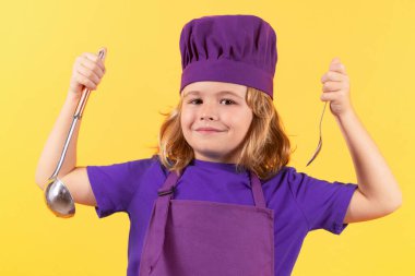 Funny kid chef cook with kitchen ladle, studio portrait. Child chef cook. Child wearing cooker uniform and chef hat preparing food, studio portrait