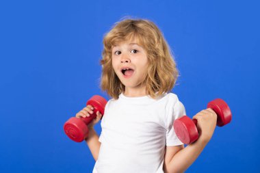 Child boy pumping up biceps muscles with dumbbell. Fitness kids with dumbbells
