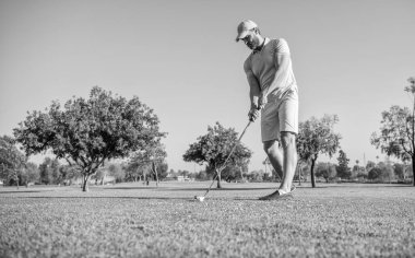 summer activity. professional sport outdoor. male golf player on professional golf course. portrait of golfer in cap with golf club. people lifestyle. sporty man playing game on green grass.