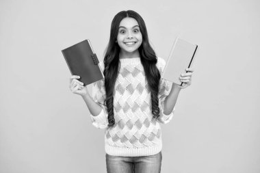 Kopya kitabı olan liseli kız izole edilmiş arka planda poz veriyor. Edebiyat dersi, ilkokul. Entelektüel çocuk okuyucu