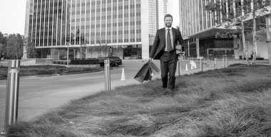 İş dünyasının kendine güvenen girişimcisi alışveriş çantası ve hediye kutusunu ofis dışında tutuyor, fotokopi alanı, iş yeri.