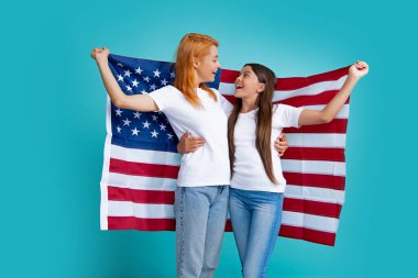 Heyecanlı anne ve çocuk Amerikan bayrağı taşıyor. Amerikan bayrağı taşıyan anne ve kız çocuğu. ABD 4 Temmuz 'u kutluyor. Bağımsızlık Günü. Vatansever Amerikan bayramı konsepti