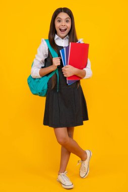 Amazed teen girl. School teenager child girl with school backpack hold book and copybook. Teenager student, isolated background. Learning and knowledge. Go study. Excited expression