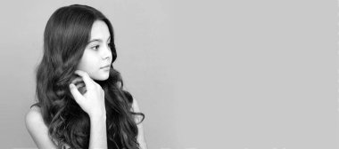 Uzun kıvırcık saçlı çocuk portresi. Yüzüne dokun, güzelim. Çocuk yüzü, yatay poster, izole edilmiş genç kız portresi, fotokopi alanı olan pankart