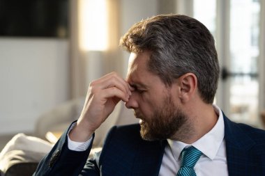 Yorgun, baş ağrısı ve dizüstü bilgisayardan dolayı göz yorgunluğu. Stres, yorgunluk ve göz yorgunluğu olan bir iş adamı. İş adamı bilgisayar işinden sonra yorgun gözlerini ovalıyor.