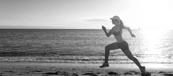 Woman run and jump on sea beach. Energetic running woman in activewear run on beach sand along seaside, runner