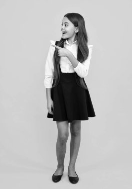 Reklamlara işaret ederek, sarı arka planda izole edilmiş, fotokopi alanında gözüken genç kızın portresini kapat. Kopyalama alanı oluştur