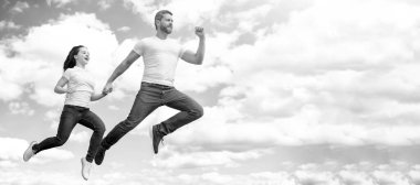 Baba ve kızı gökyüzüne sıçrıyor, fotokopi alanı olan bir pankart. Enerjik baba ve kız gökyüzüne atlıyorlar..