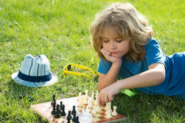 Ребенок Играет Шахматы Весеннем Заднем Дворе Лежит Траве Сконцентрированный Ребенок — стоковое фото