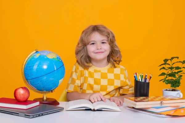 Stock image Back to school. Funny little boy from elementary school with book. Portrait of school boy isolated on yellow studio background. Education