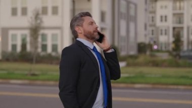 İş adamının iş görüşmesi var. Kafkasyalı iş adamı iş görüşmesi yapıyor. İş adamı telefonda konuşuyor. İş görüşmesinde işadamı konuşuyor..