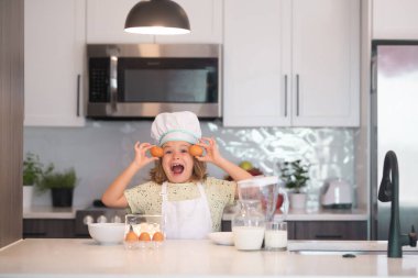 Çocuk aşçı yumurtalarla yemek yapıyor. Aşçı çocuk ev mutfağında pasta yapmayı öğreniyor. Çocuk lezzetli yapıyor. Kurabiye ya da krep pişirmek için yumurta, süt ve un malzemesi.