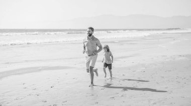 daddy and child family running on summer beach, family sport.