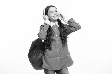 Öğrenmeye hazır kulaklıklı okul kızı. Okul çantalı çocukların izole edilmiş beyaz stüdyo geçmişleri var.