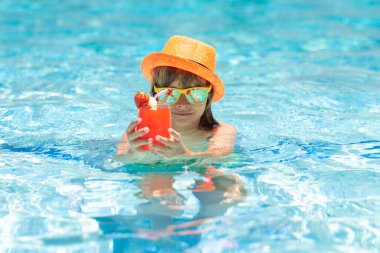 Kid in swimming pool with summer cocktail. child swim on summer pool. Beach sea and water fun