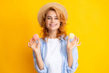 Çekici bir kadın lezzetli bir badem kurabiyesini ısırmak istiyor. Makarnayı ağzının kenarında tutuyor. Güzellik kızı tatlıdan hoşlanıyor.