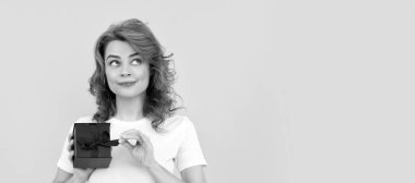 Sarı arka planda hediye kutusuyla gülümseyen kız, boks günü. İzole edilmiş yüz portresi, taklit alanı olan pankart