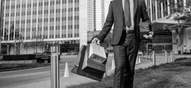 Adam alışveriş torbalarını tutuyor. Erkekler günü. Elinde paketler olan kırpılmış bir iş adamı. Satış ve indirim. Ona sürpriz yapacağım. Sevgilim olur musun? Boks günü. Elinde hediye kutusu olan yürüyen bir adam. Girişimci doğum günü hediyesi taşır..