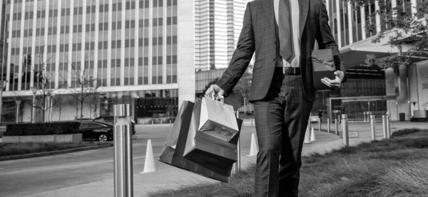 stock image guy hold shopping bags. mens day. cropped businessman with packages. sale and discount. surprise for her. be my valentine. boxing day. walking man with present box. entrepreneur carry birthday gift.