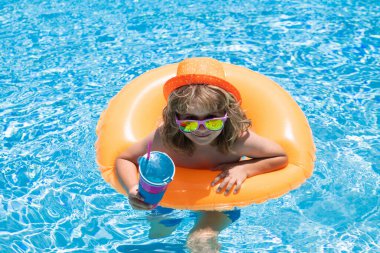 Yüzme havuzundaki çocuk şişme yüzükte. Su oyuncağı, çocuklar için sağlıklı açık hava sporları. Çocuklar plaj eğlencesi. Yaz su havuzunda su sıçratan çocuk