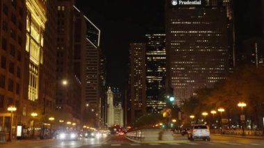 Chicago, ABD - 30 Nisan 2023: Sokak yolu ve gökdelenli Chicago şehrinin gece manzarası, zaman aşımı.