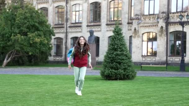 上学的少女背着背包跑步 在公园里跑来跑去的少女的慢动作 学校的少女在户外跑步 正在外面跑的少女 — 图库视频影像