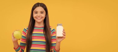 Mutlu çocuk elma ve ilaç şişesi tutuyor sarı arka plan, ek. Ayrı çocuk yüzünün yatay posteri, afiş başlığı, kopyalama alanı