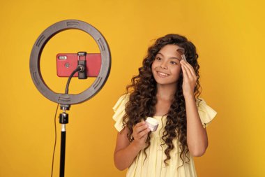 Gençler çevrimiçi medya videosu kaydediyor. Genç kız çevrimiçi yayın yapıyor ve cep telefonu uygulaması ile sosyal medya içeriğini paylaşıyor. Mutlu ergen, pozitif ve gülümseyen genç kız duyguları