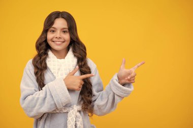 Reklamlara bak. Ergen çocuk noktaları bir yana, metin tanıtım fikri sunumu için boş kopya alanı gösterir, sarı arkaplan karşısında poz verir