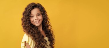 Uzun kıvırcık saçlı, mükemmel ciltli, sağlıklı saçlı neşeli bir çocuk. Çocuk yüzü, yatay poster, izole edilmiş genç kız portresi, fotokopi alanı olan pankart