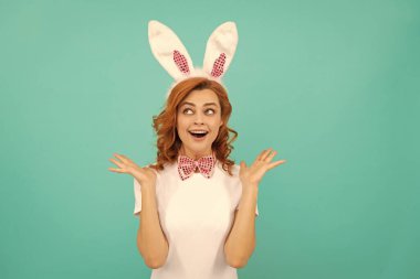 Tavşan kulaklı mutlu Paskalya kızı ve mavi arka planda papyon..