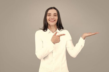 Kadın fotokopi alanını işaret ediyor, kopyalama alanını gösteriyor. Promosyon, reklam içerikli jest gösteren kız, elle tavsiye edilen ürünü işaret ediyor. Heyecanlı kadın modeli