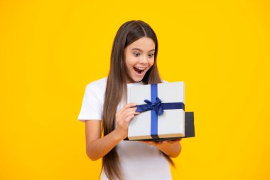 Child with gift present box on isolated background. Presents for birthday, Valentines day, New Year or Christmas. Excited teenager, glad amazed and overjoyed emotions