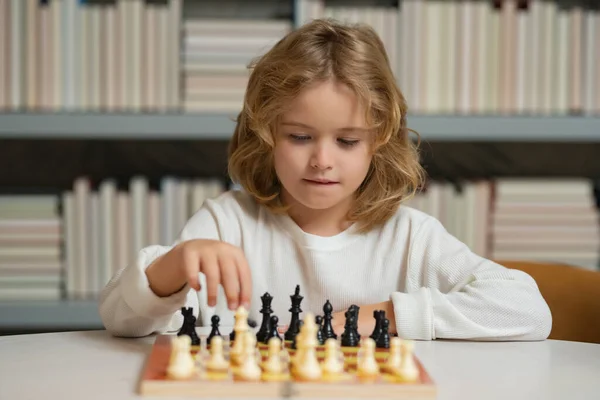 stock image Chess game for children. Shool kid playing chess in classroom. Kids early development. Boy kid playing chess at home. Portrait close up, funny face