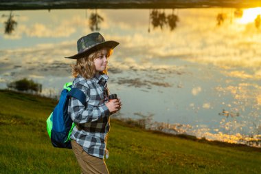 Sırt çantalı çocuk, gezgin ya da kâşif. Keşif ve keşif kavramı. Çocuk doğa seyahatleri, macera ve turizm, boş geziler. Seyahat ve macera tatili