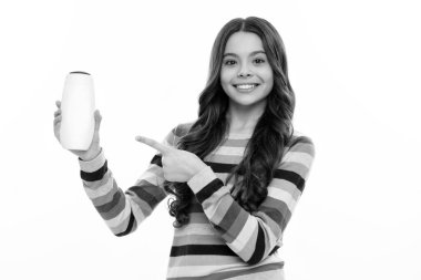 Child teen girl with shampoos conditioners and shower gel. Long hair care of teenager. Presenting cosmetic product, shampoo bottle. Happy girl face, positive and smiling emotions