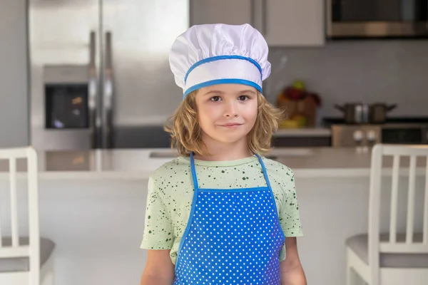 厨房里有趣的儿童厨师的画像 有趣的孩子厨师在厨房做饭 大厨男孩做健康的食物 小孩儿头戴厨师帽的画像 — 图库照片