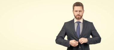 Ciddi profesyonel bir adam resmi takım elbise giyme kuralını ayarlar. Beyaz ve resmi kıyafetlerle izole edilir. İnsan yüzü portresi, fotokopi alanı olan pankart. Takım elbiseli bir iş adamı, izole stüdyo geçmişi var.