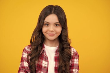 Mutlu ergen, pozitif ve gülümseyen genç kız duyguları. Sarı stüdyo arka planında gülümseyen güzel genç kızın portresi.