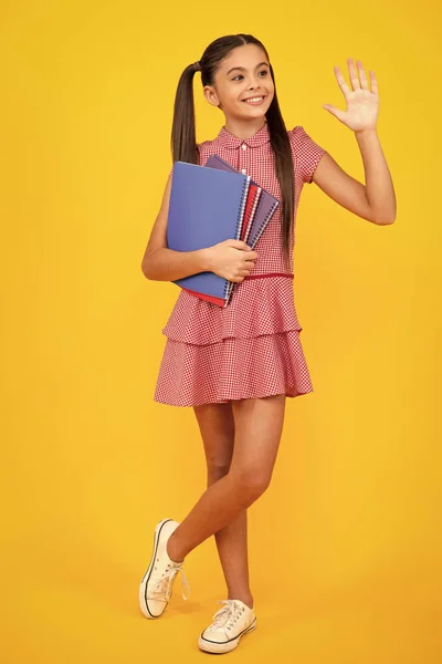 回学校去带着书本准备学习的未成年女学生 在校女童在孤立的黄色工作室背景 快乐的少女 积极的微笑的少女的情感 — 图库照片
