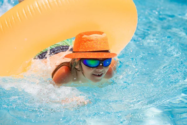 膨脹可能なリングのプールの子供 小さな男の子はオレンジのフロートで泳ぐ 子供のための水のおもちゃ 子供のための健康的な屋外スポーツ活動 子供のビーチの楽しみ — ストック写真