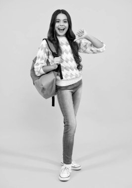 Heyecanlı bir yüz. Sırt çantalı liseli kız. Tecrit edilmiş genç bir öğrenci. Öğrenme ve bilgi. Git çalış. Çocuk eğitimi konsepti. Şaşırtıcı bir ifade, neşeli ve mutlu.