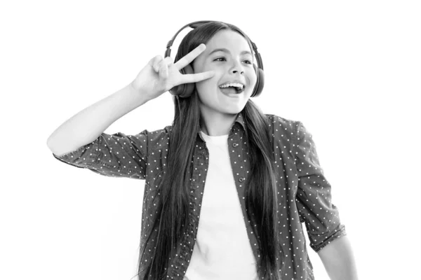ヘッドフォンで音楽を聴いている若い十代の子供 女の子はワイヤレスヘッドフォンを介して曲を聞く ワイヤレスヘッドセットデバイスアクセサリー 感情的な驚きの肖像画若いです女の子 — ストック写真
