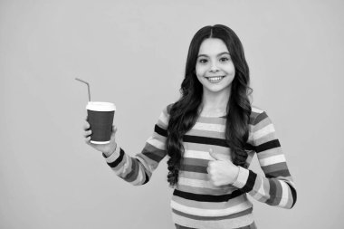 Elinde kahve fincanı tutan kız çocuğu. Kahve molası ve ara. Gençlerin elinde plastik bardaklar, kakao, kahve ya da çay içecekleri var. Mutlu ergen, pozitif ve gülümseyen genç kız duyguları