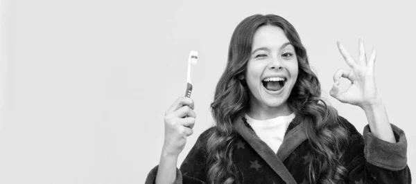 健康的で美しい笑顔 最高の歯磨き粉を使って 子供の習慣病です わかりましたジェスチャー 歯ブラシ付きの子供の女の子のバナー スタジオの肖像画 コピースペース付きヘッダー — ストック写真