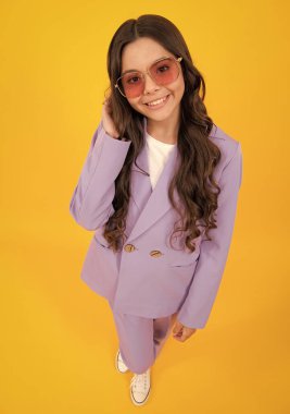 Güzel bir genç kızın tam boy fotoğrafı sarı arka planda izole edilmiş günlük kıyafetler giyiyor.