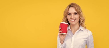 cheerful blonde woman with coffee cup and smartphone on yellow background. Woman isolated face portrait, banner with mock up copy space
