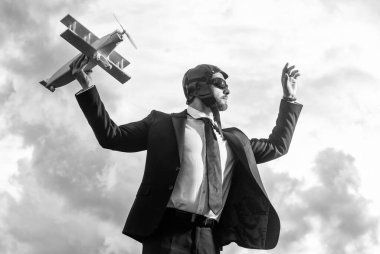 Takım elbiseli hırslı iş adamı ve pilot şapkalı uçak oyuncağı..